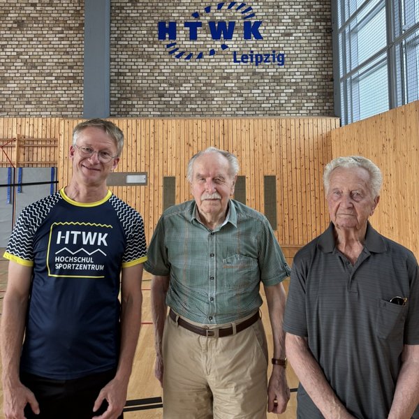 drei Herren in einer Sporthalle