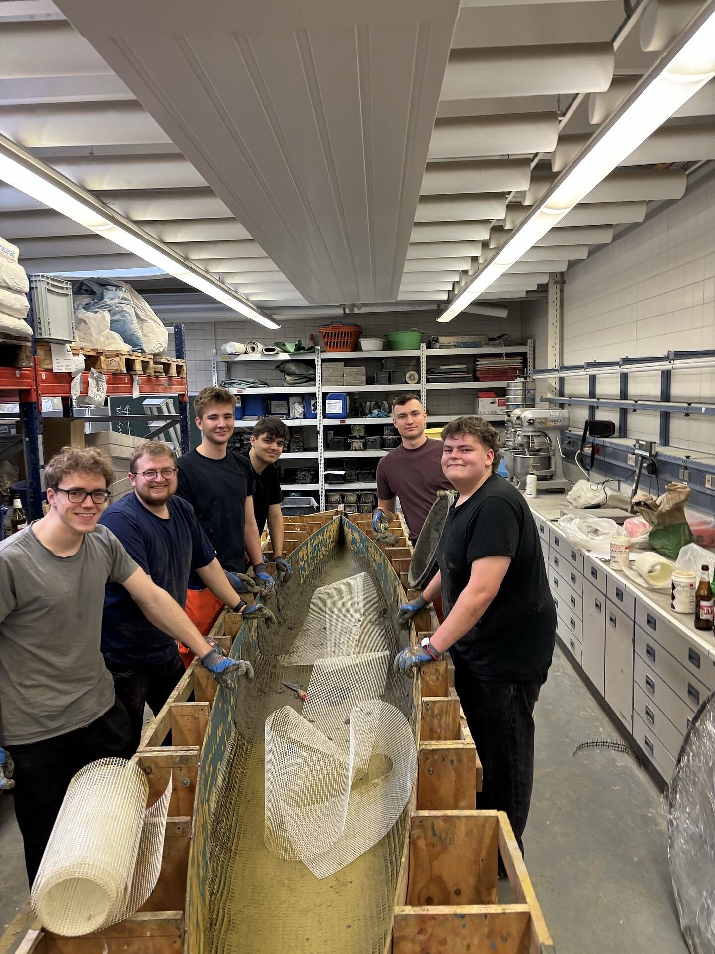 Gruppe von Personen baut ein Boot aus Beton