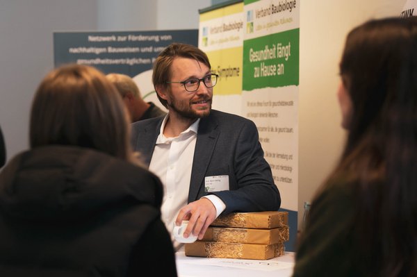 ein Mann unterhält sich an einem Messestand