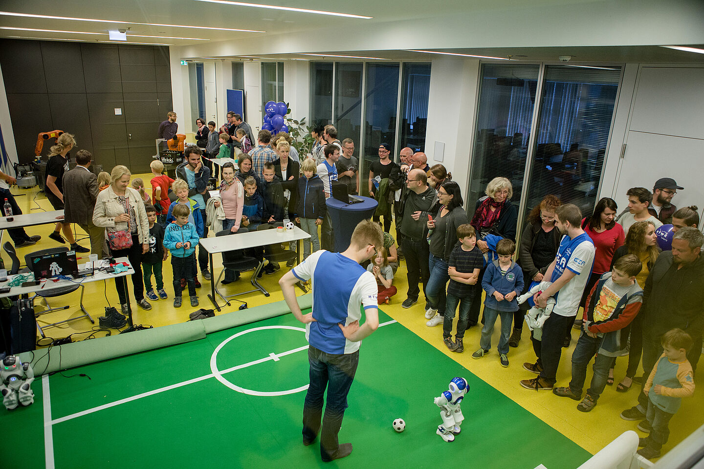 Wissenschaftsnacht 2018 Ein Fußballroboter mit seinem menschlichen „Trainer“ auf dem Kunstrasen.