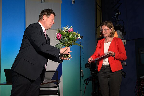 Die Preise des HTWK-Fördervereins 2020 wurden pandemiebedingt während einer (fast ausschließlich) virtuellen Veranstaltung verliehen. Prof. Markus Krabbes übergibt den Preis an Maris Klein. (Foto: © Cecilia Schammler) Mann übergibt Frau einen Blumenstrauß
