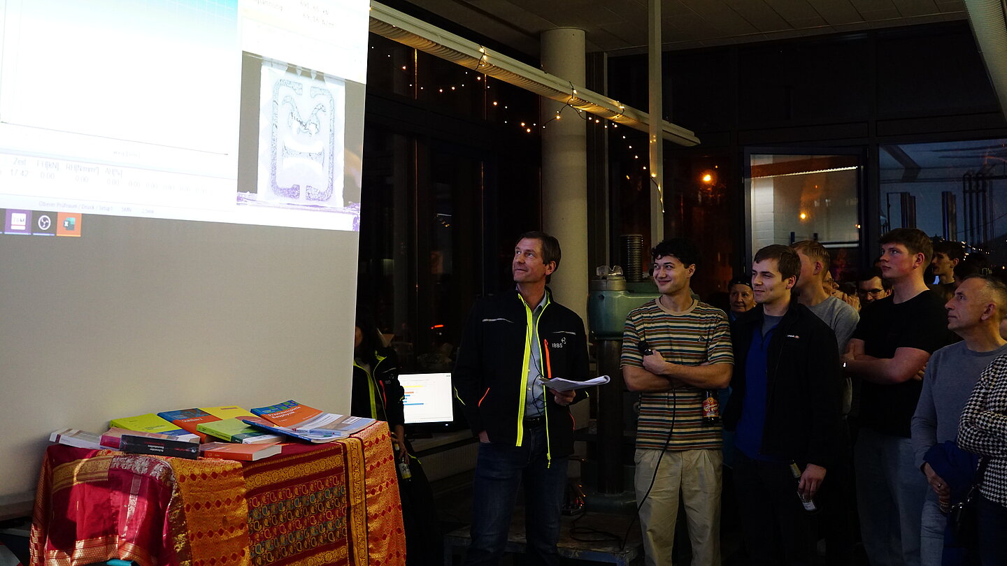 Gruppe Studierende verfolgen die Prüfung auf der Leinwand